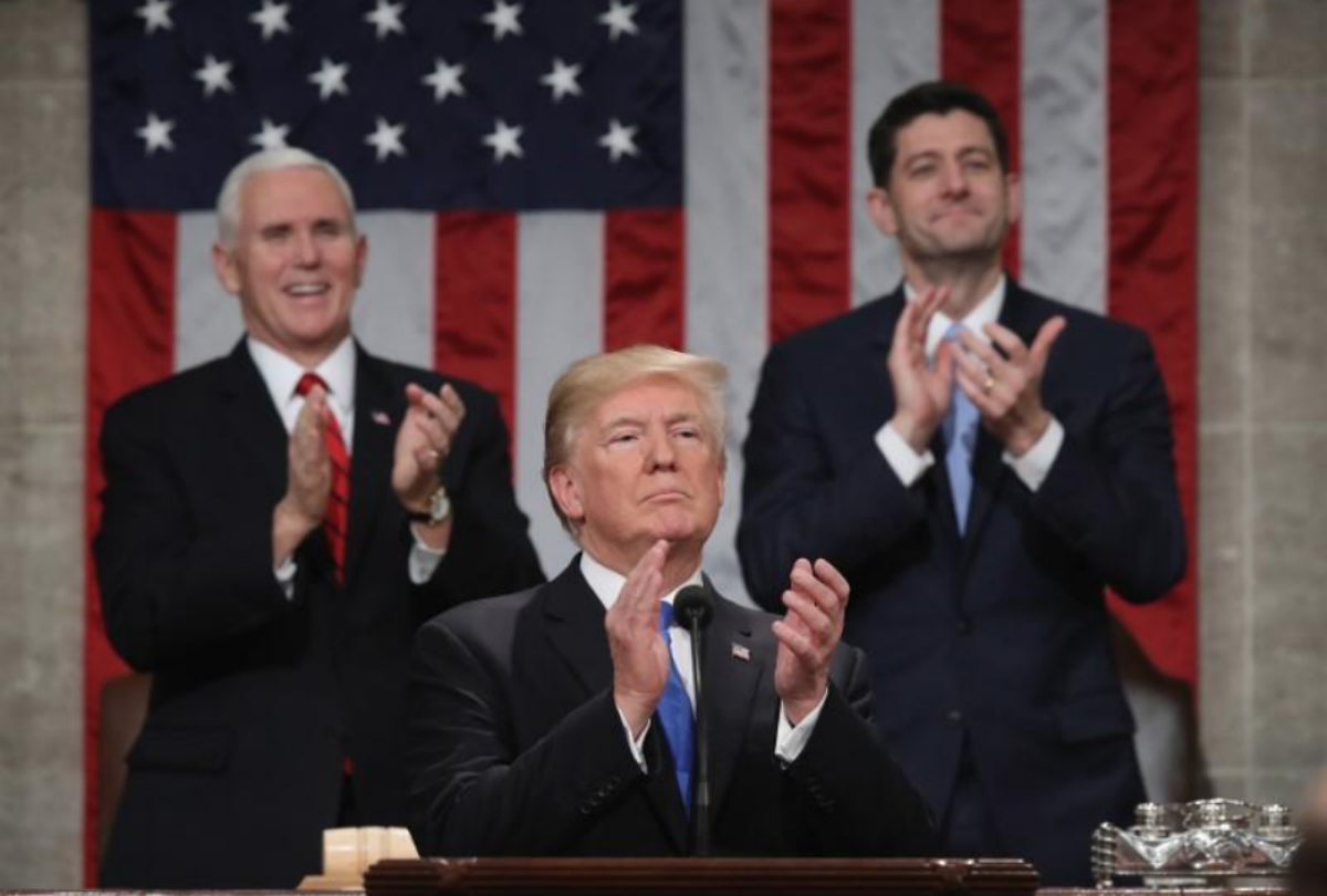 FILE PHOTO - U.S. President Donald Trump applauds in front of U.S. Vice President Mike Pence (L) and Speaker of the House U.S. Rep. Paul Ryan (R-WI) during his first State of the Union address to a joint session of Congress inside the House Chamber on Capitol Hill in Washington, U.S., January 30, 2018. REUTERS/Win McNamee/Pool