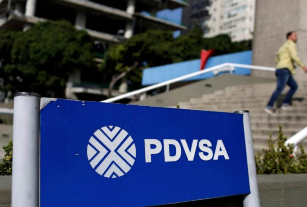 FILE PHOTO: A man walks past a gas station with the logos of the Venezuelan state oil company PDVSA in Caracas, Venezuela December 23, 2016. REUTERS/Carlos Garcia Rawlins/File Photo