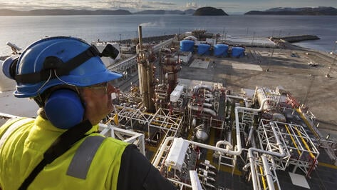 oil worker looking over gas plant